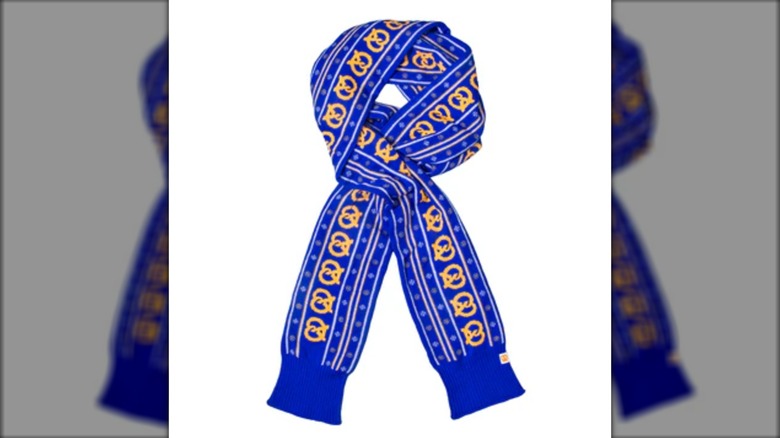 A long blue scarf with patterns of pretzels and small snowflakes