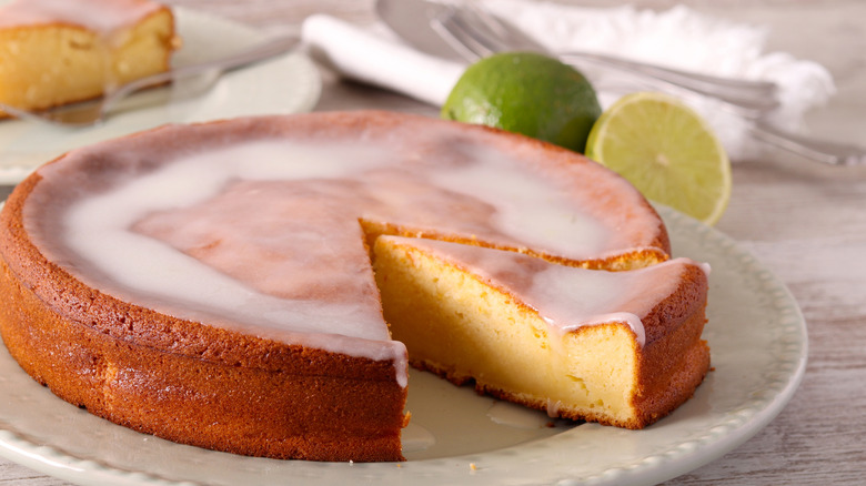 A glazed yogurt cake with a slice being pulled out of it