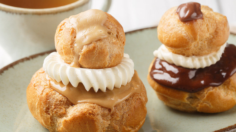 Two religieuse desserts of different flavors on a plate