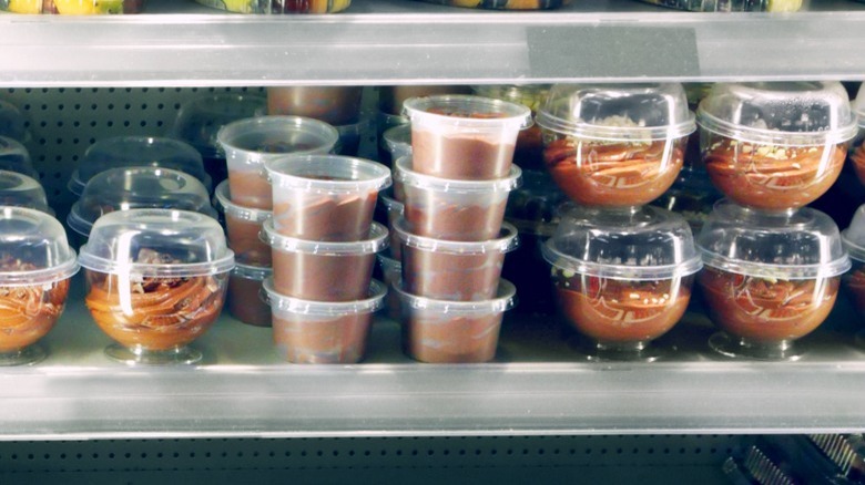 Cups of pudding in refrigerator