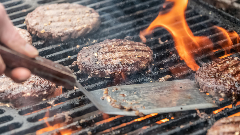 person flipping burger patties
