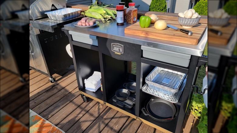 Oklahoma Joe's DLX rolling workstation prep and storage with food, spices, cookware, and tools