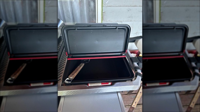 Weber Works XL outdoor storage bin with a grilling utensil inside