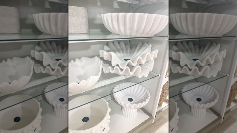 White ruffled bowls and centerpieces on shelves