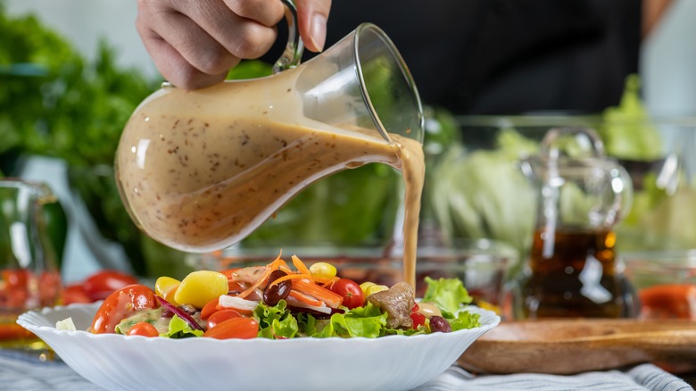 pouring dressing on salad
