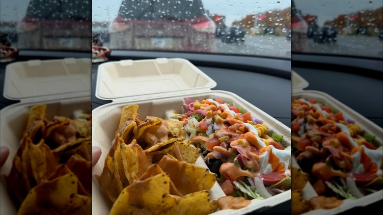 Person holding B-Box from barBURRITO while sitting in a car