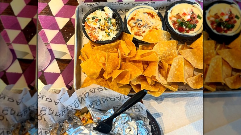 Food from Condado Tacos, including a portion of tortilla chips and dips and burritos