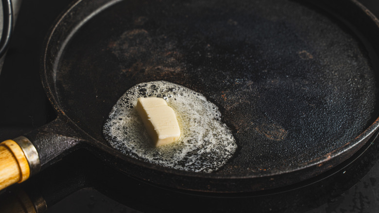 Butter melting in black pan
