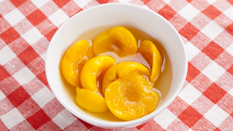 Canned peaches in white bowl