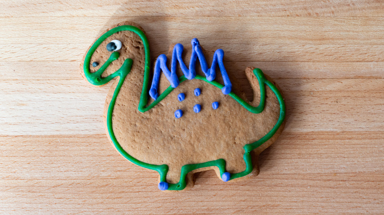 Dinosaur cookie outlined with blue and green royal icing