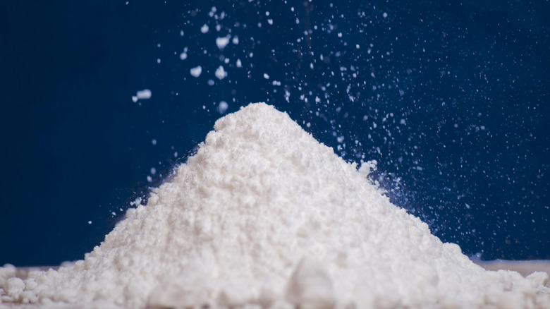 Pile of white powdered sugar on a blue background