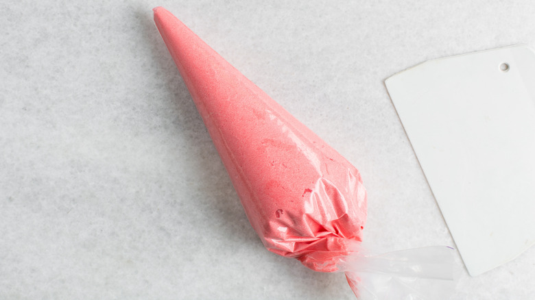 Plastic piping bag filled with pink icing