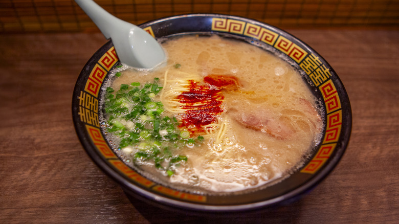 Bowl of tonkotsu-style ramen, with chili oil and green onions as toppings