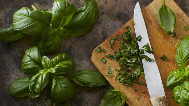 fresh basil sliced on chopping board with whole basil leaves