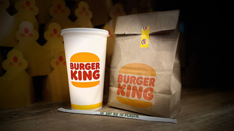 Burger King meal in a paper bag, with a drink and straw