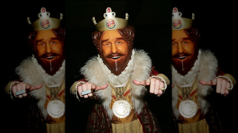 Burger King "King" mascot wearing a plastic mask and jewelry