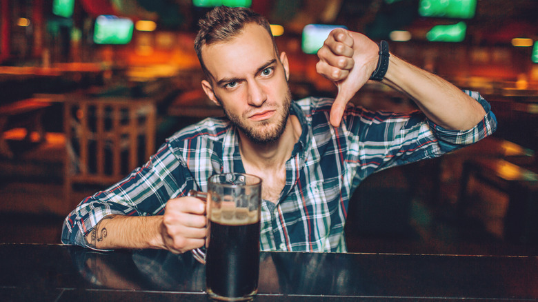 Man drinking bad-tasting beer