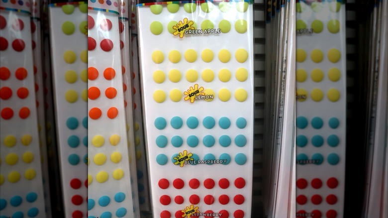 Plastic-wrapped sheets of candy buttons in assorted sour flavors