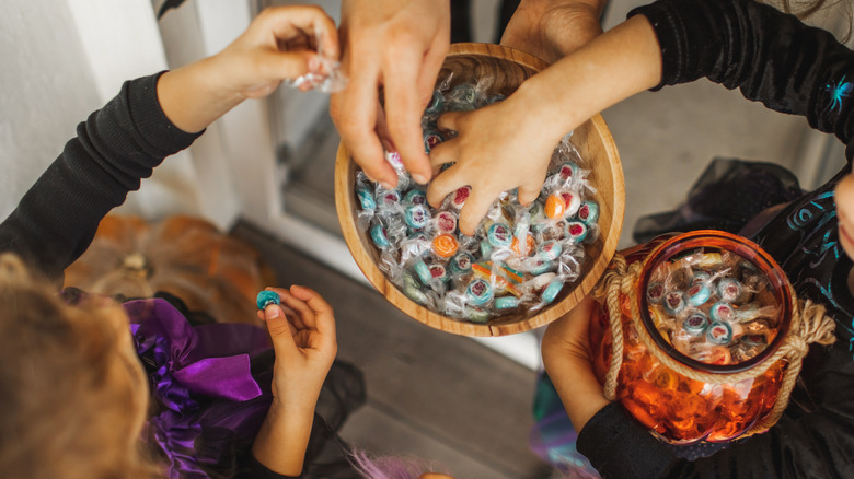 Two trick-or-treating girls collecting candy