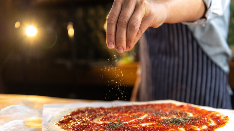 Sprinkling oregano on pizza
