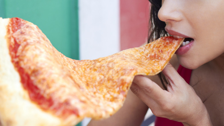 Woman eating giant pizza slice