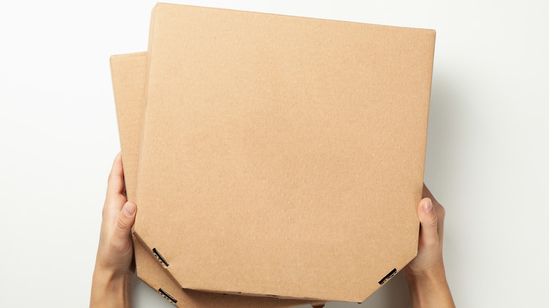 Person holding pizza boxes