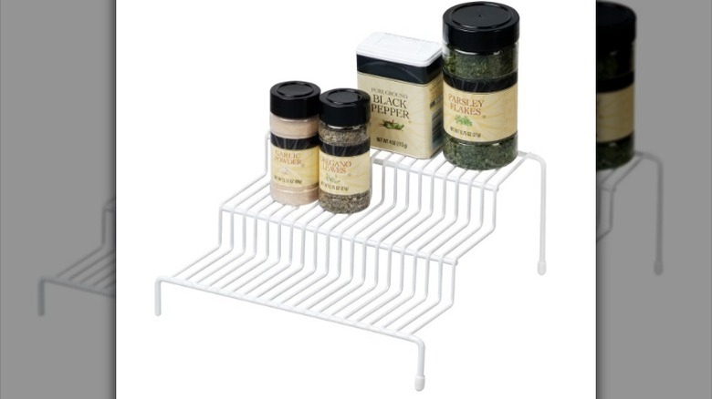 Spice rack with spices on white background