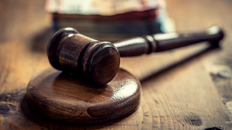 A judge's gavel rests against a wooden stand