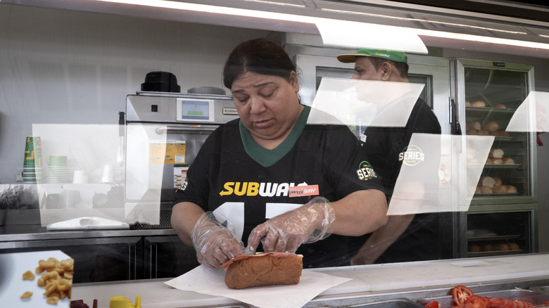 A Subway worker prepares a sandwich