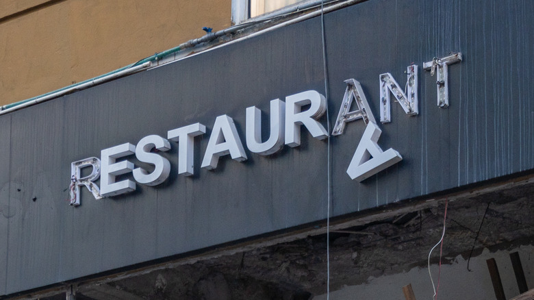 Broken shopfront restaurant sign