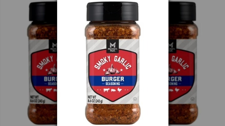 Smoky garlic burger seasoning with a red and blue label, clear bottle, and black lid on white background