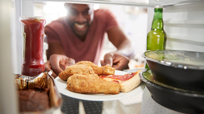 person taking chicken from fridge