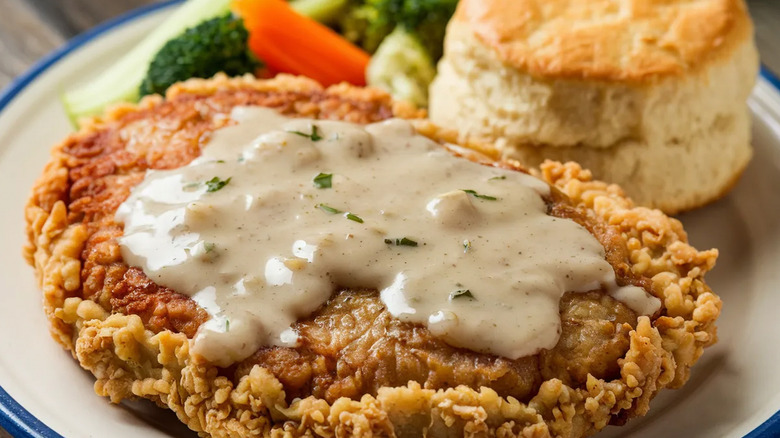 Chicken fried steak and biscuits on plate