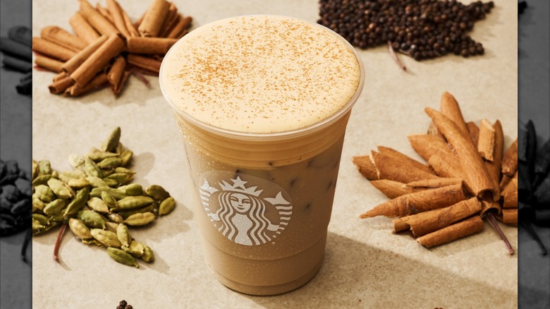Starbucks' iced pumpkin cream chai surrounded by ingredients arranged to look like leaves
