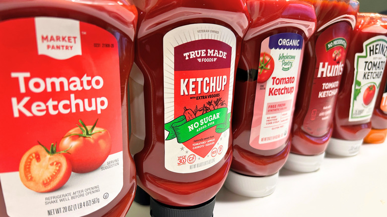 Close up of several ketchup bottles from different brands