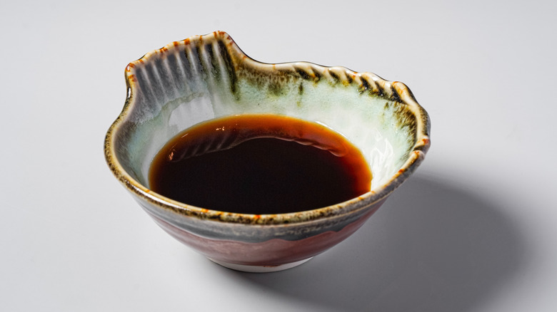 Some ponzu dipping sauce sits in a decorative bowl.