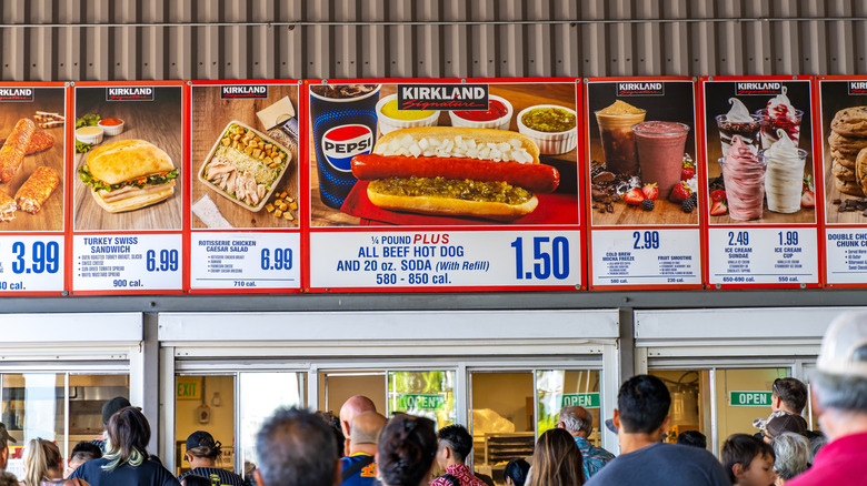 Signs above Costco food court displaying its menu items, with its All Beef Hot Dog in the center