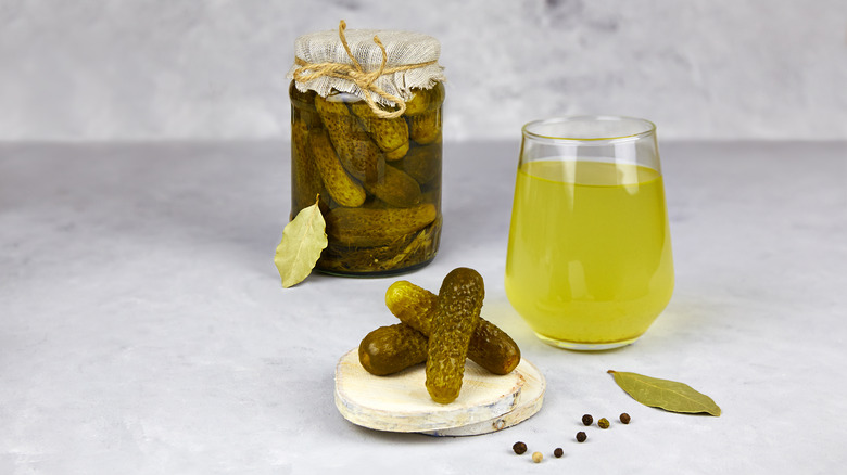 glass of pickle juice and pickles