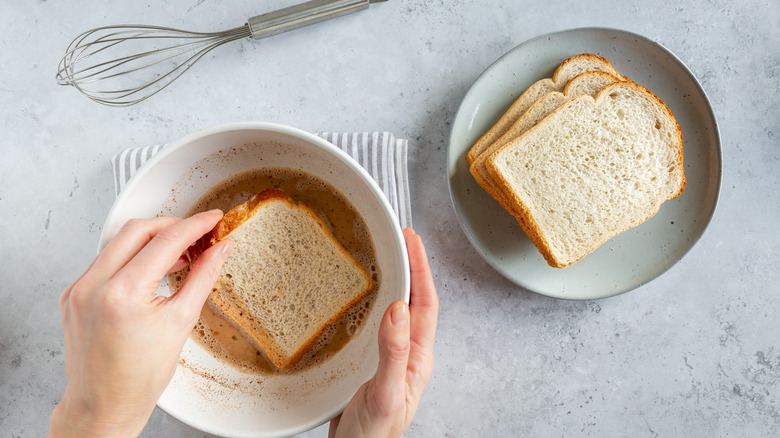 person soaking bread for French toast