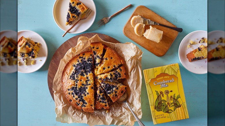 A box of Trader JOe's cornbread mix with a tray of blueberry cornbread