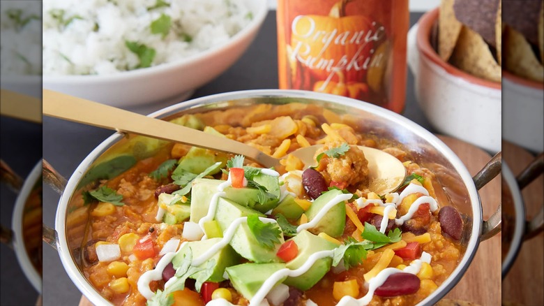 A can of Trader Joe's organic canned pumpkin with a mixing bowl of pumpkin and other ingredients