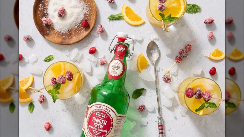 A green bottle of Trader Joe's triple ginger brew sparkling beverage, with glasses of the same