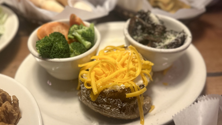 A baked potato topped with sour cream and cheese