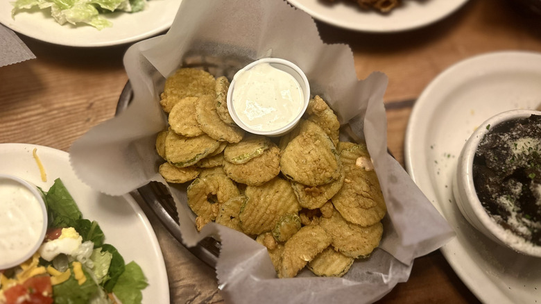 Crispy fried pickles with dipping sauce in a Texas Roadhouse restaurant