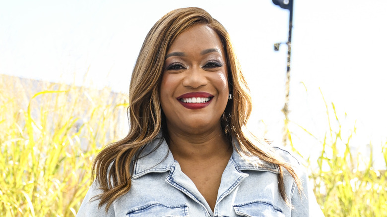 Sunny Anderson, cheerfully standing outside on a sunny day