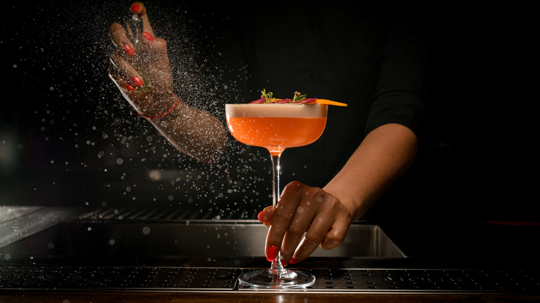 bartender with brightly colored cocktail