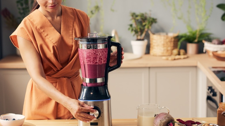 woman adjusting blender speed