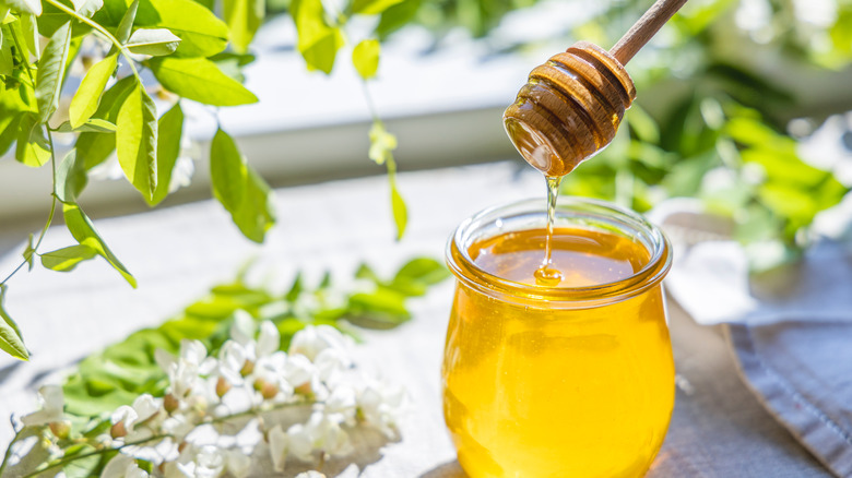 drizzling honey over jar