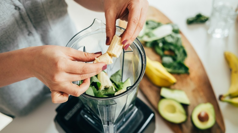 adding smoothie ingredients to blender