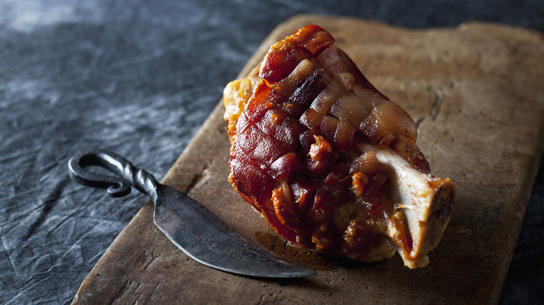 Cooked ham hock on a wooden board